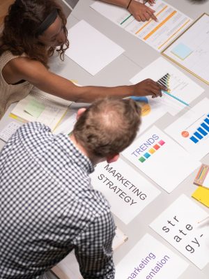 Team discussing marketing strategies in a modern office setting with charts and documents.