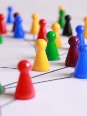A strategic arrangement of colorful pawns connected on a game board, symbolizing networking and teamwork.